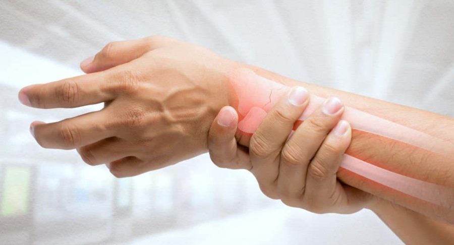 Man massaging painful wrist on a white background. Pain concept